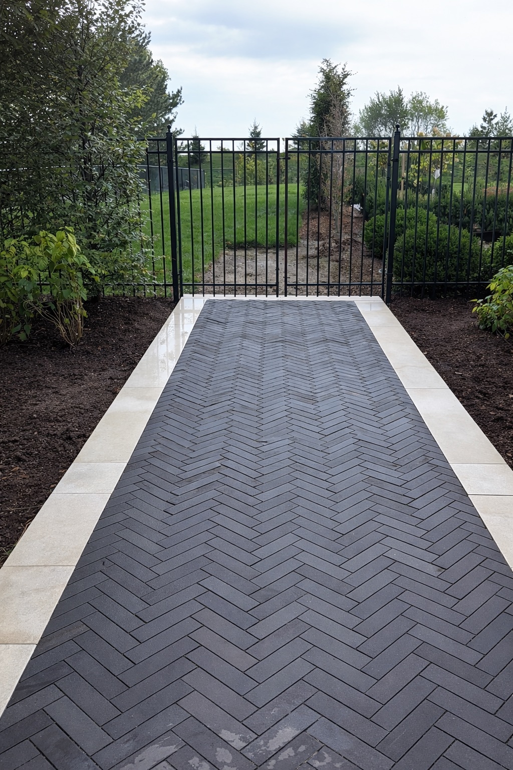 Herringbone walkway with iron gate
